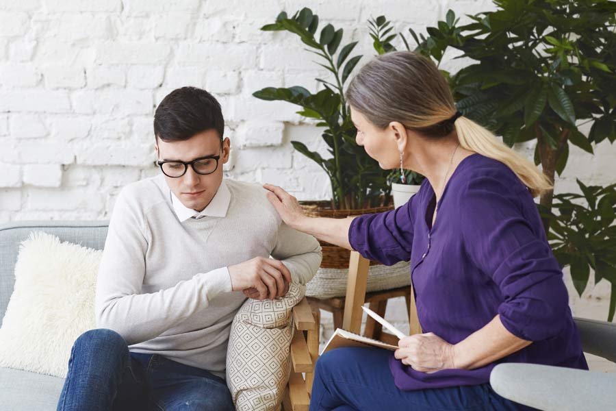 Dospersonas hablando, mujer y hombre, la mujer lo está aconsejando